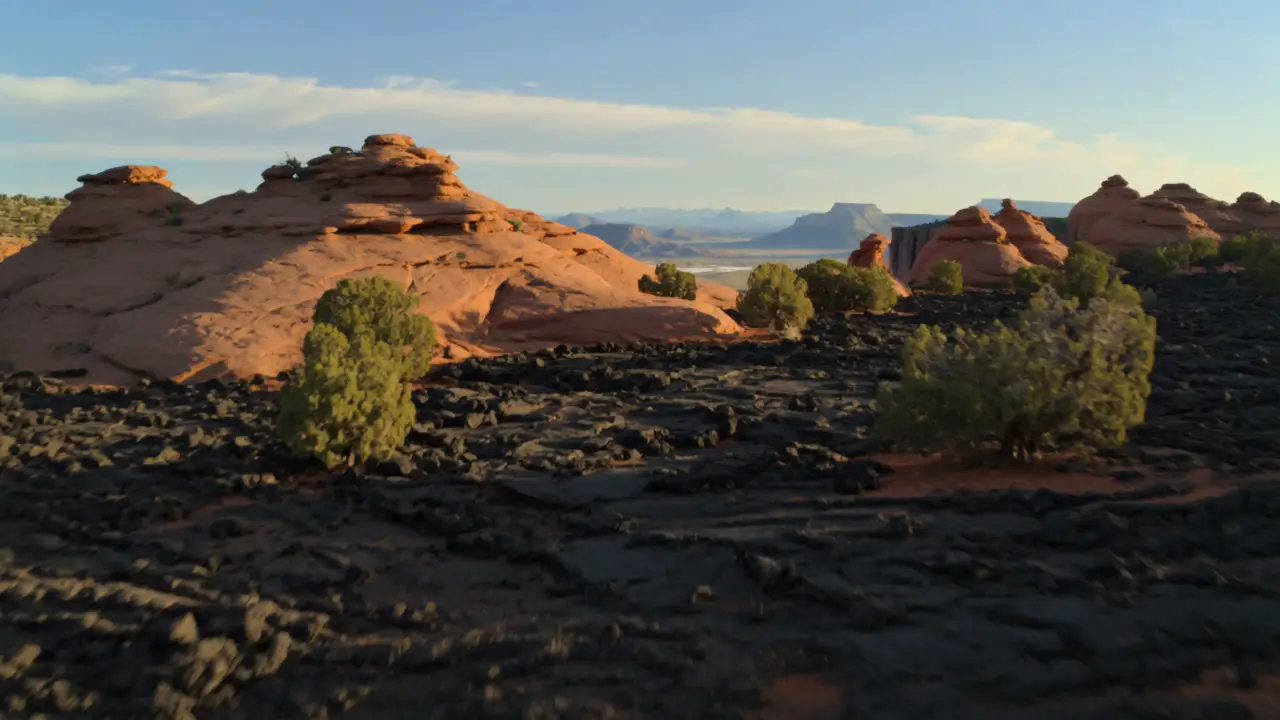 A red rock ridge and black lava rock fields in a high desert